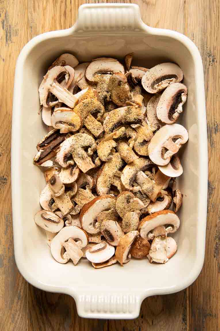 Mushrooms being baked in a casserole dish.