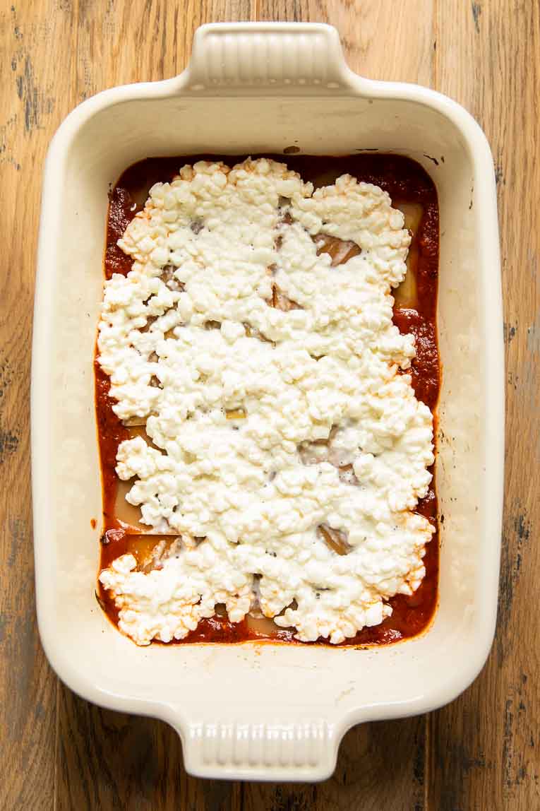 Cottage cheese over a layer of uncooked lasagna.