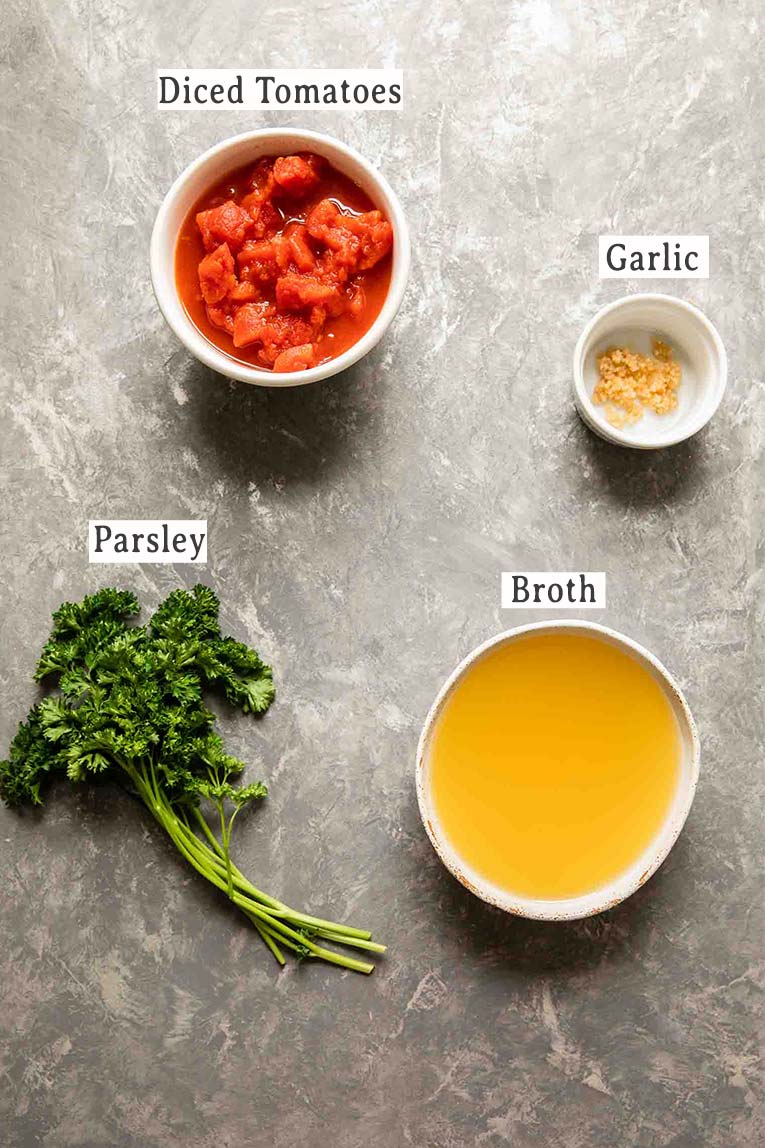 Top shot of broth and herbs ingredients for crockpot vegetable soup.