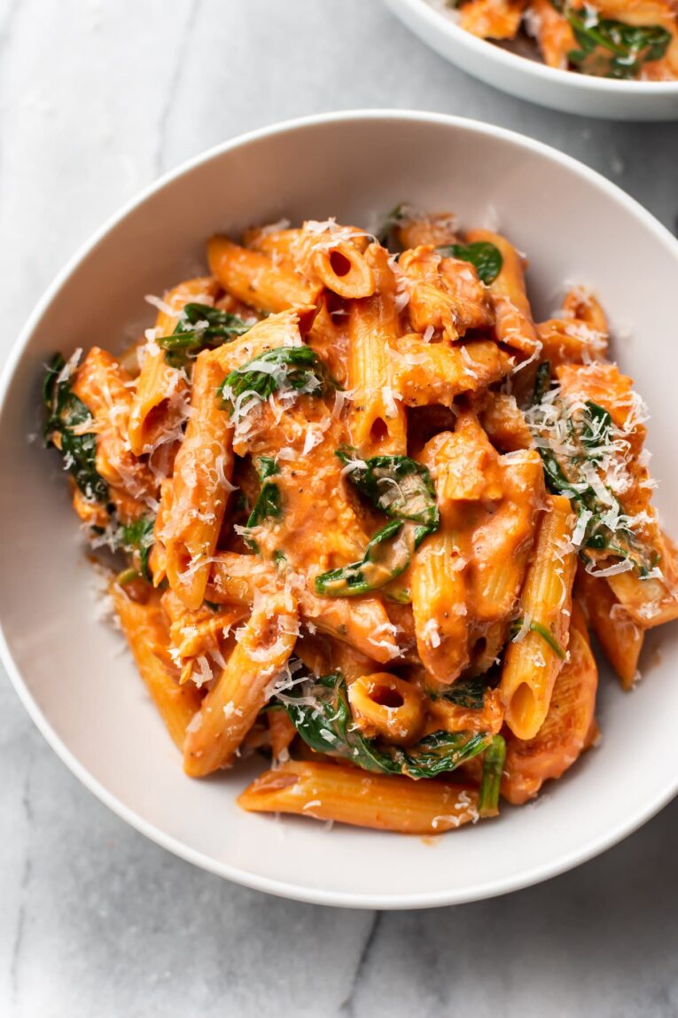 Tomato Spinach Chicken Pasta in a white bowl.