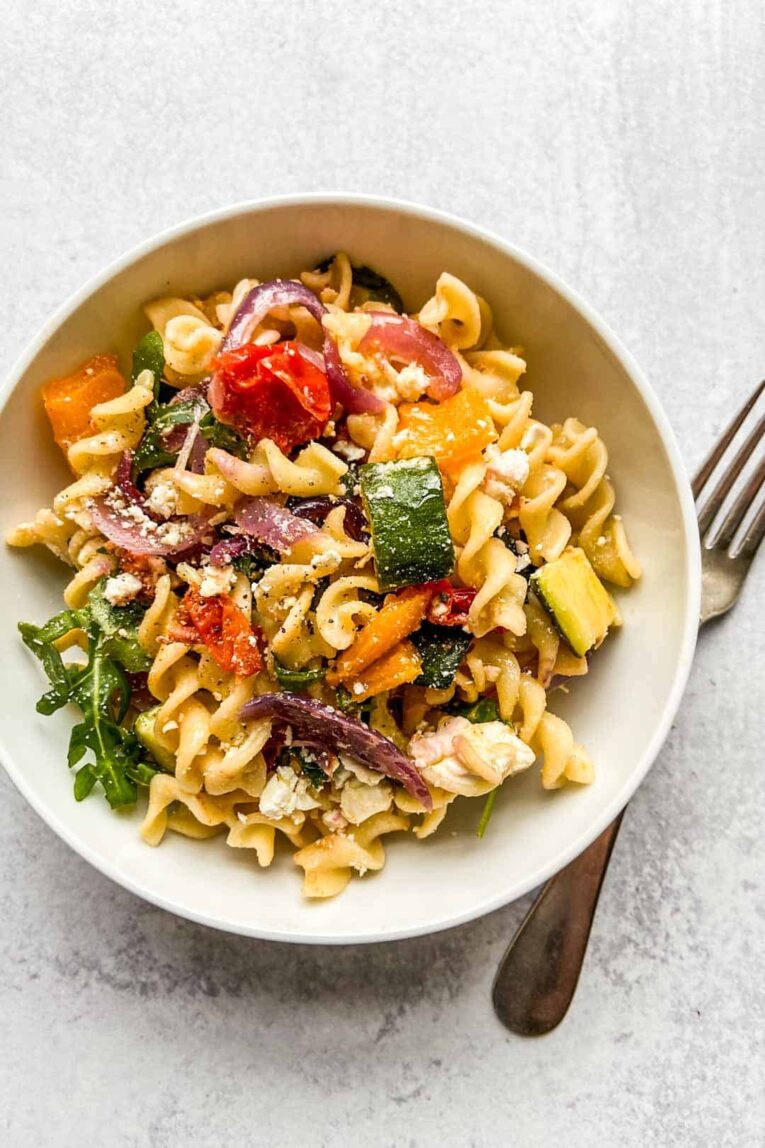 Roasted Veggie Pasta with Feta in white bowl with fork.