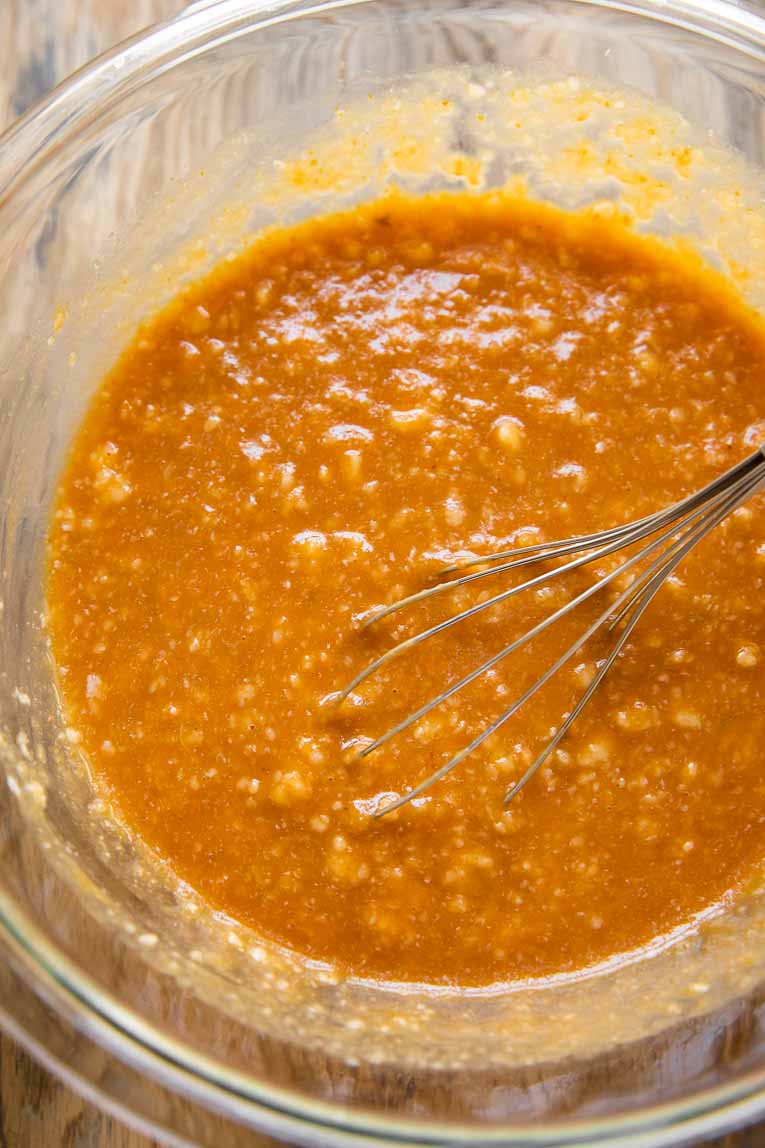 Liquid ingredients for pumpkin bread being whisked together.
