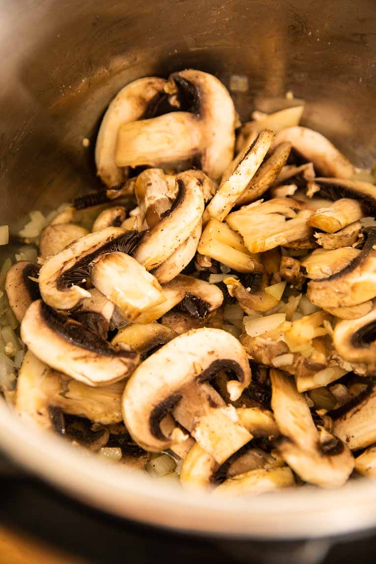 Mushrooms and garlic using the sauté feature in an Instant Pot.