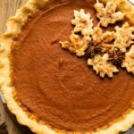 Top shot of dairy free pumpkin pie on a wood table.