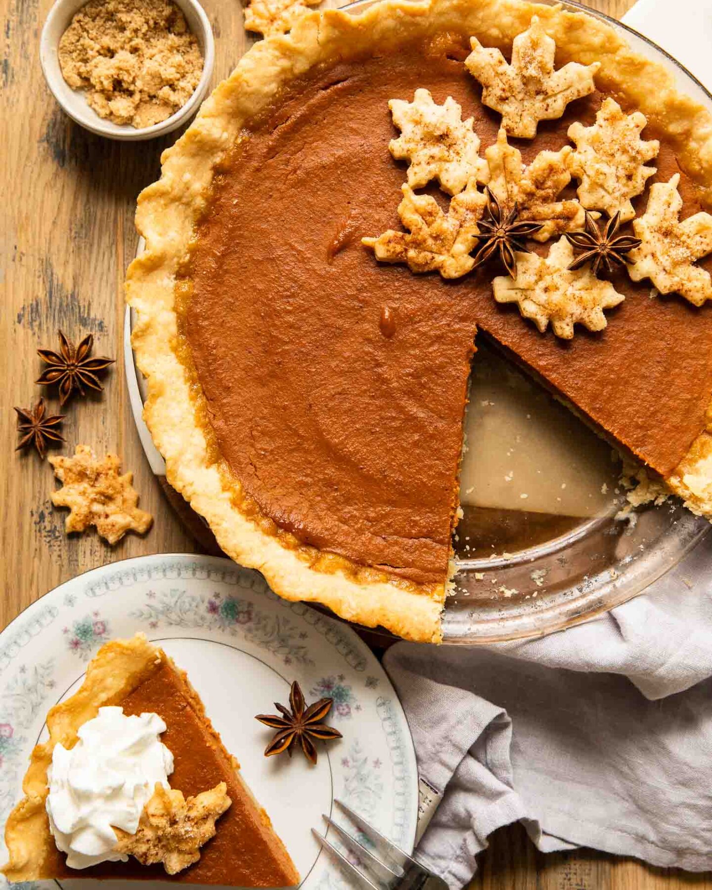 Slice of dairy free pumpkin pie on a plate next to entire pie.