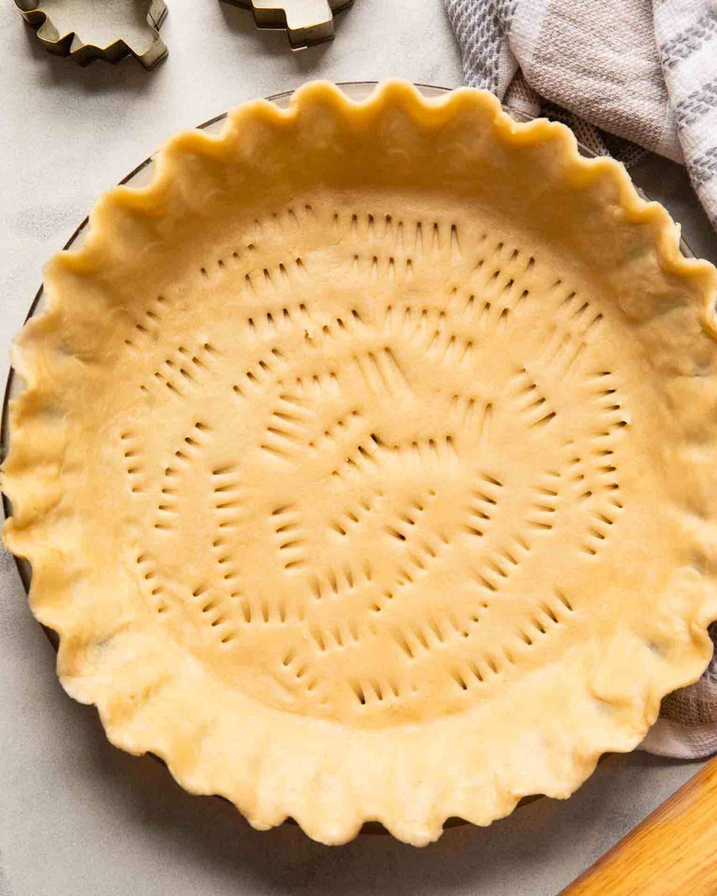 Top shot of vegan pie crust in a pan with a rolling pin.