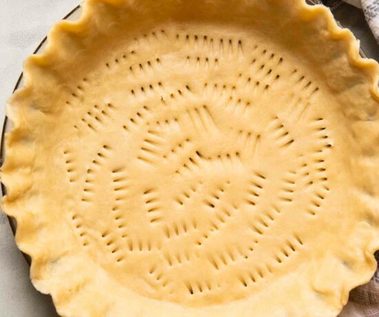 Top shot of vegan pie crust in a pan with a rolling pin.