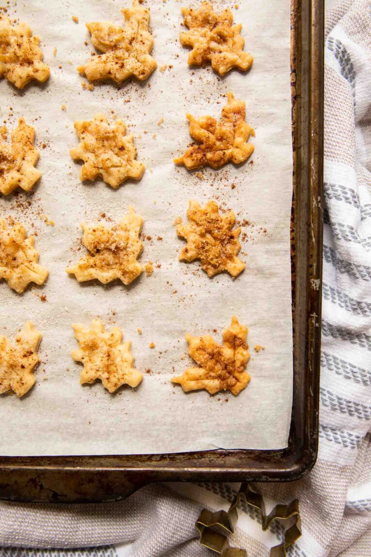 Freshly baked pie crust cookies on a baking sheet.