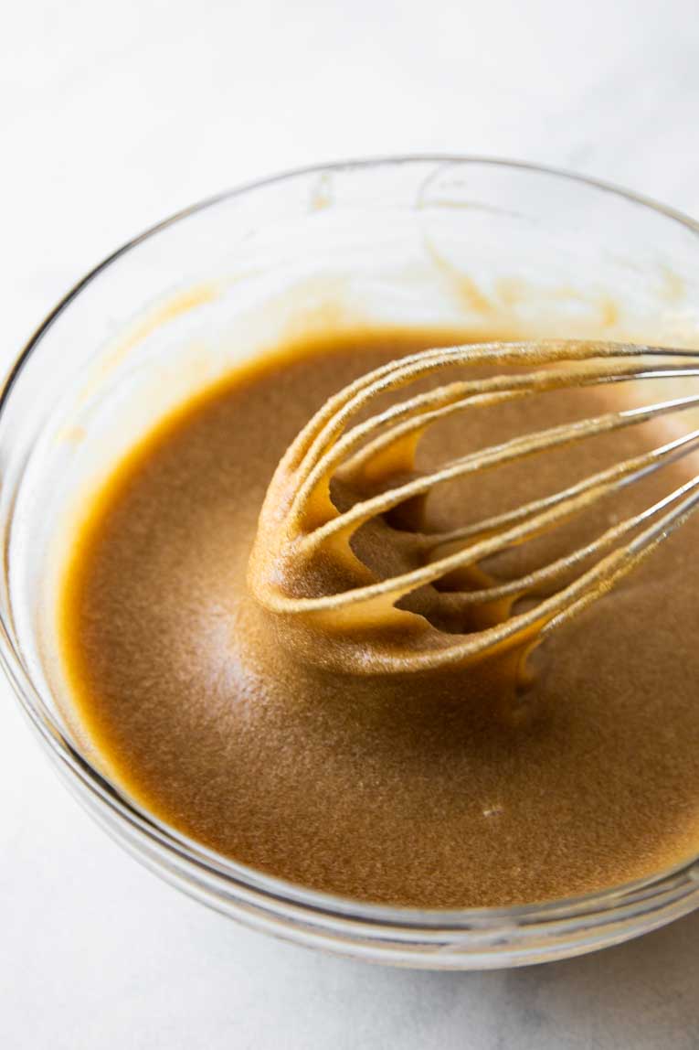 Liquid ingredients for eggnog cookies being whisked together.