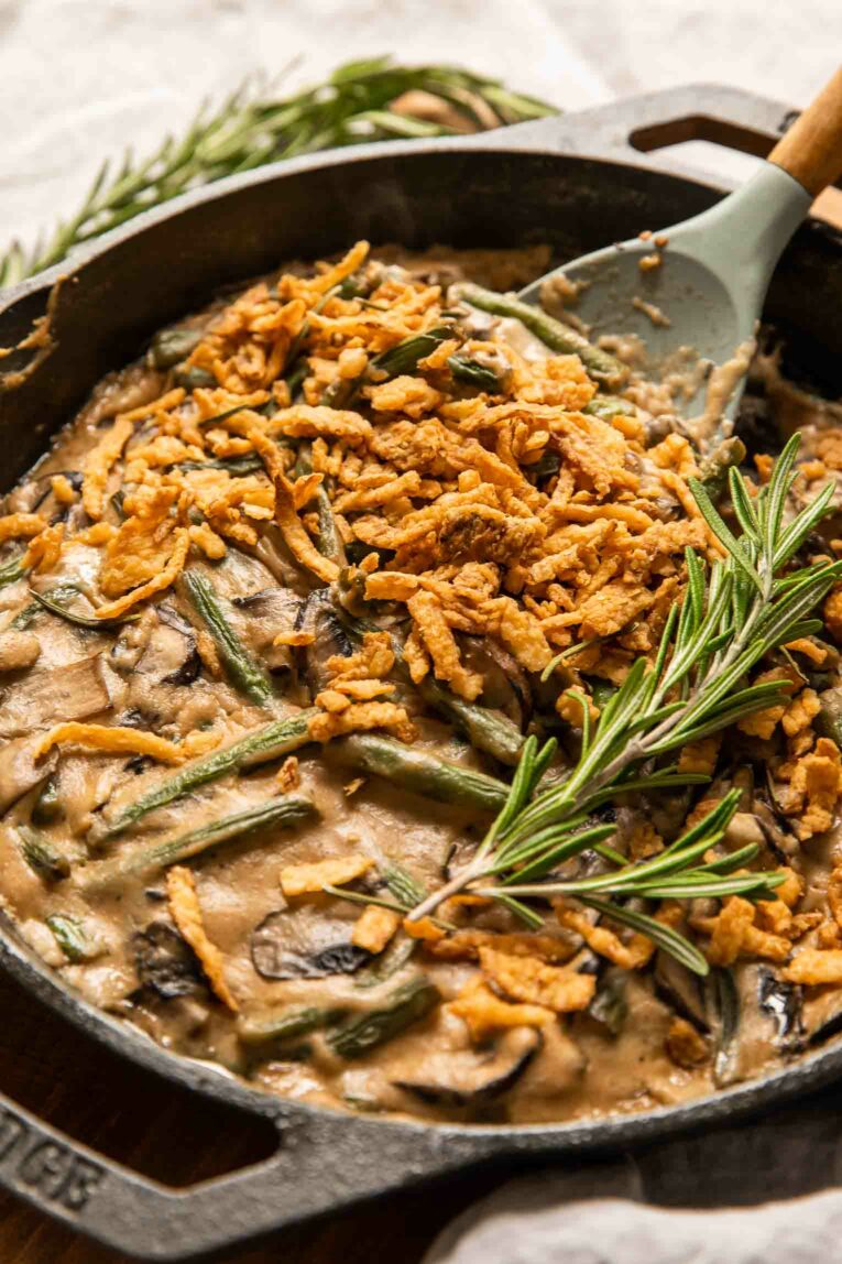 Angled shot of vegan green bean casserole in a cast iron skillet.