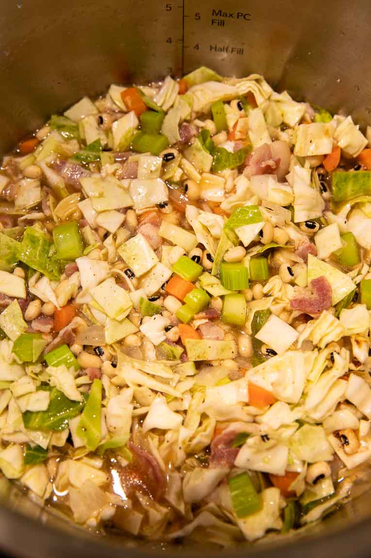 Cabbage, black eyed peas, broth, and veggies in an Instant Pot base.