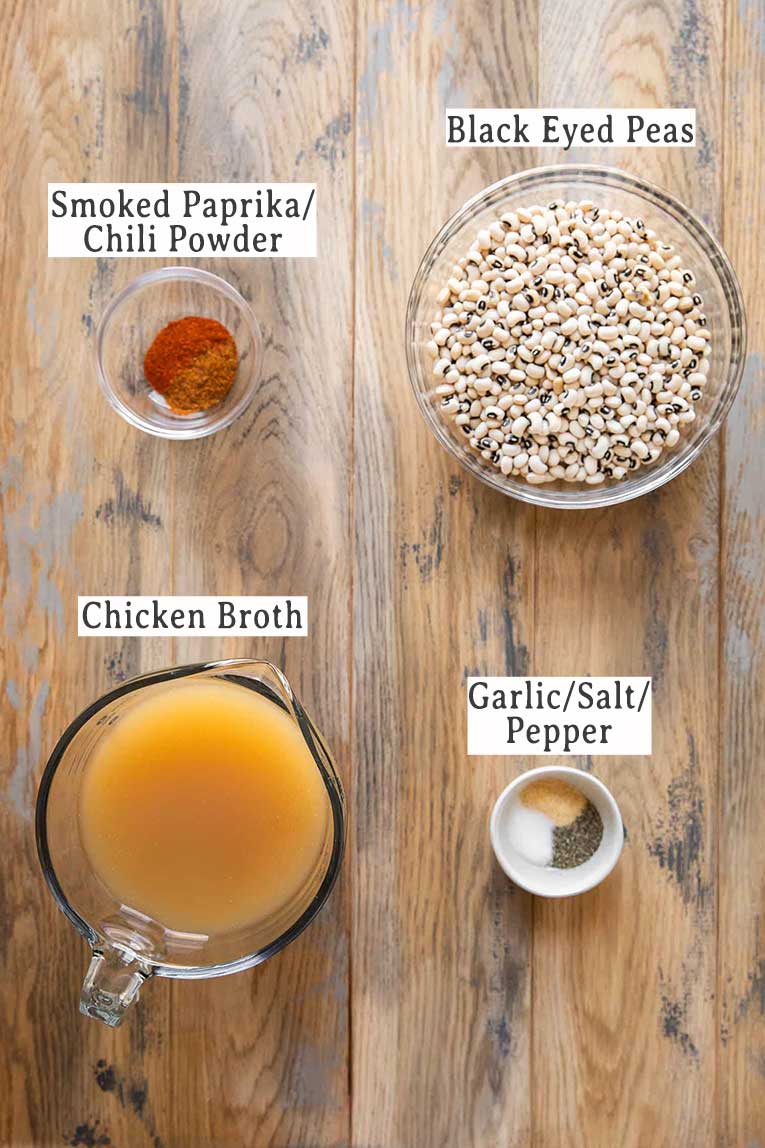 Seasoning, black eyed peas, and broth on a table.