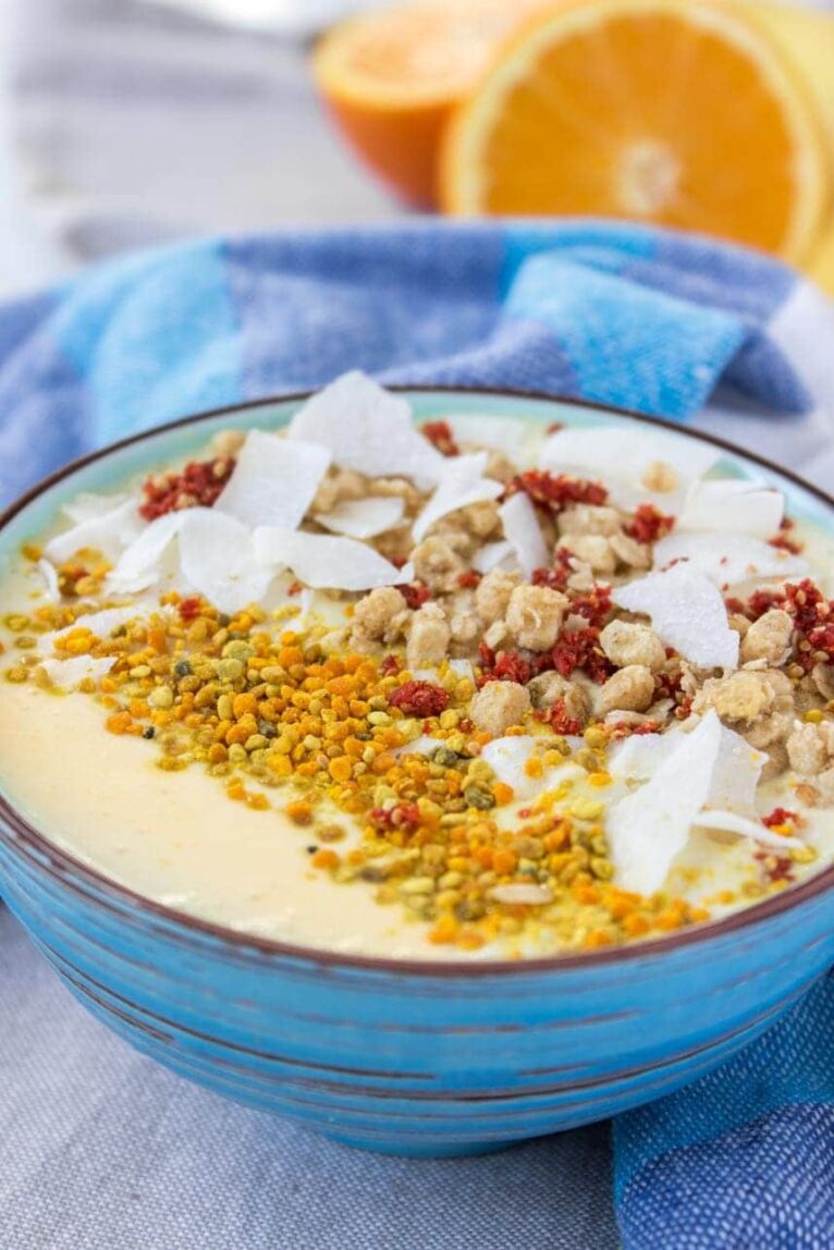 Mango turmeric smoothie bowl recipe in a blue bowl.