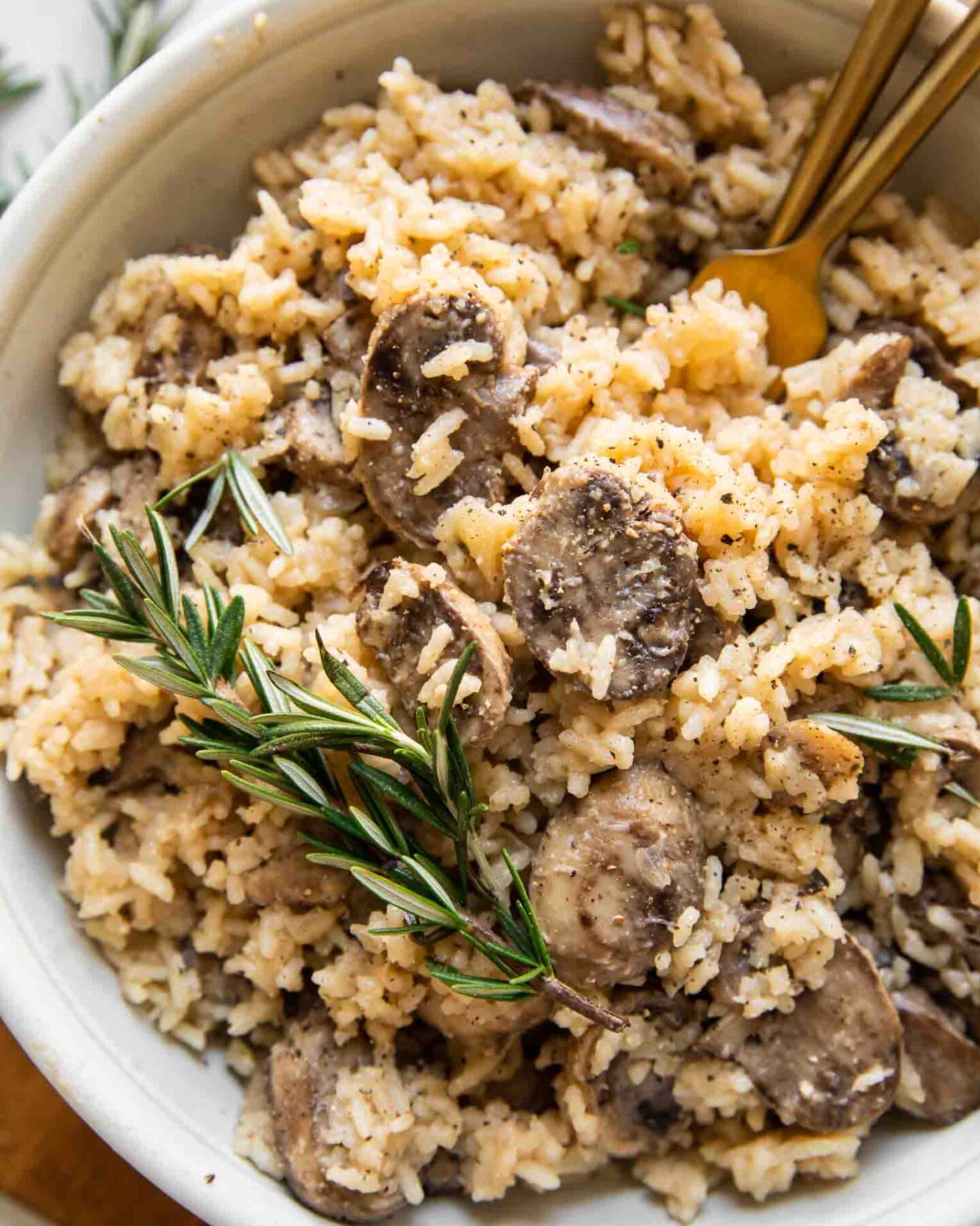 Top shot of large bowl of rice pilaf with mushrooms and rosemary.