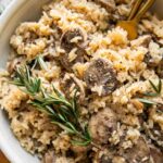Top shot of large bowl of rice pilaf with mushrooms and rosemary.
