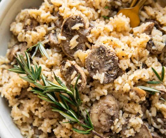 Top shot of large bowl of rice pilaf with mushrooms and rosemary.