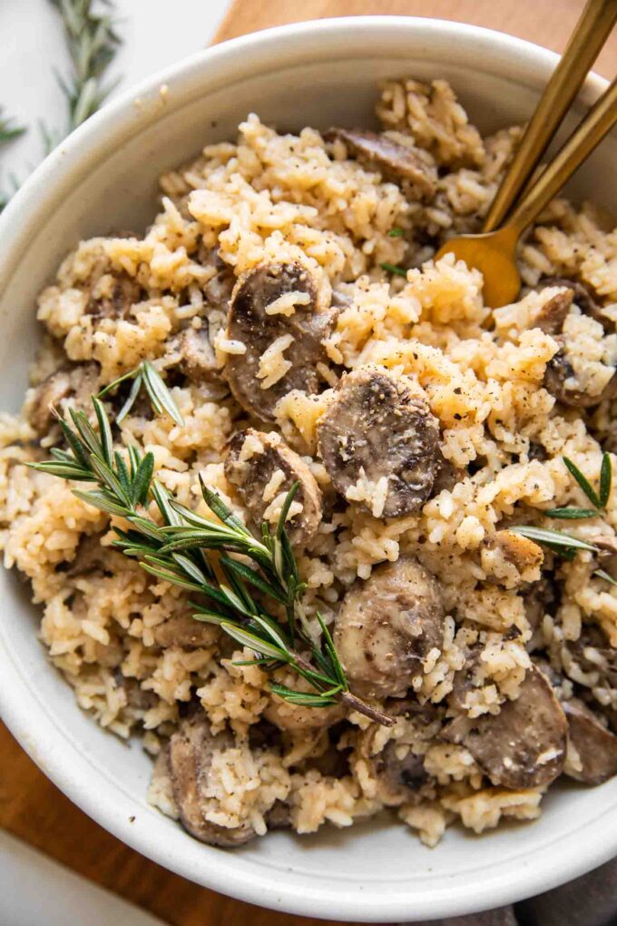 Top shot of large bowl of rice pilaf with mushrooms and rosemary.