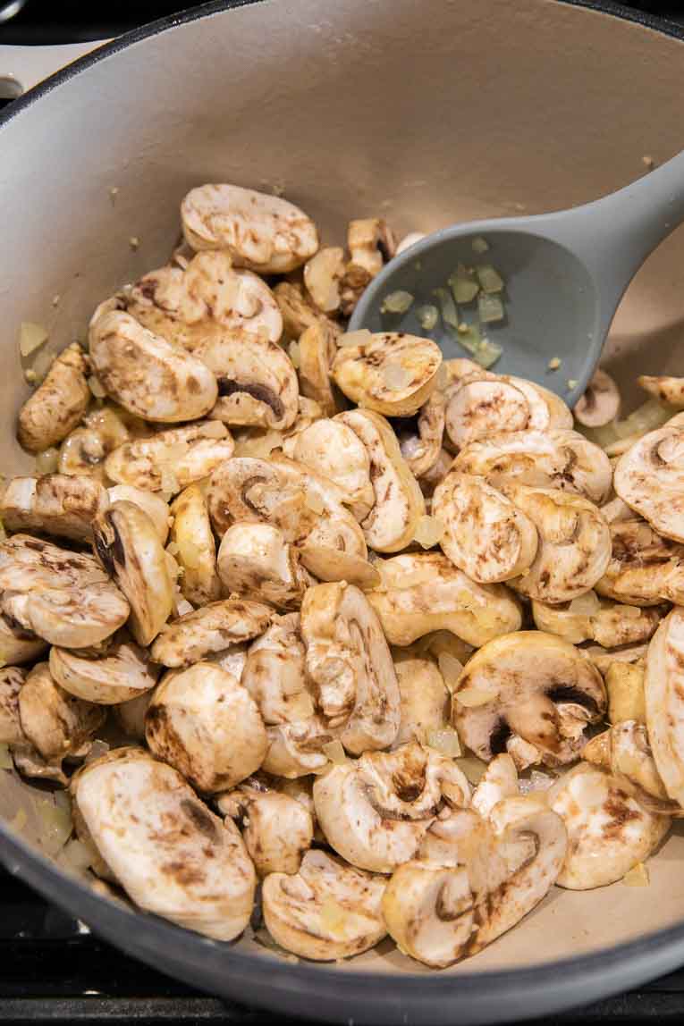 Mushrooms being sautéed in a dutch oven.