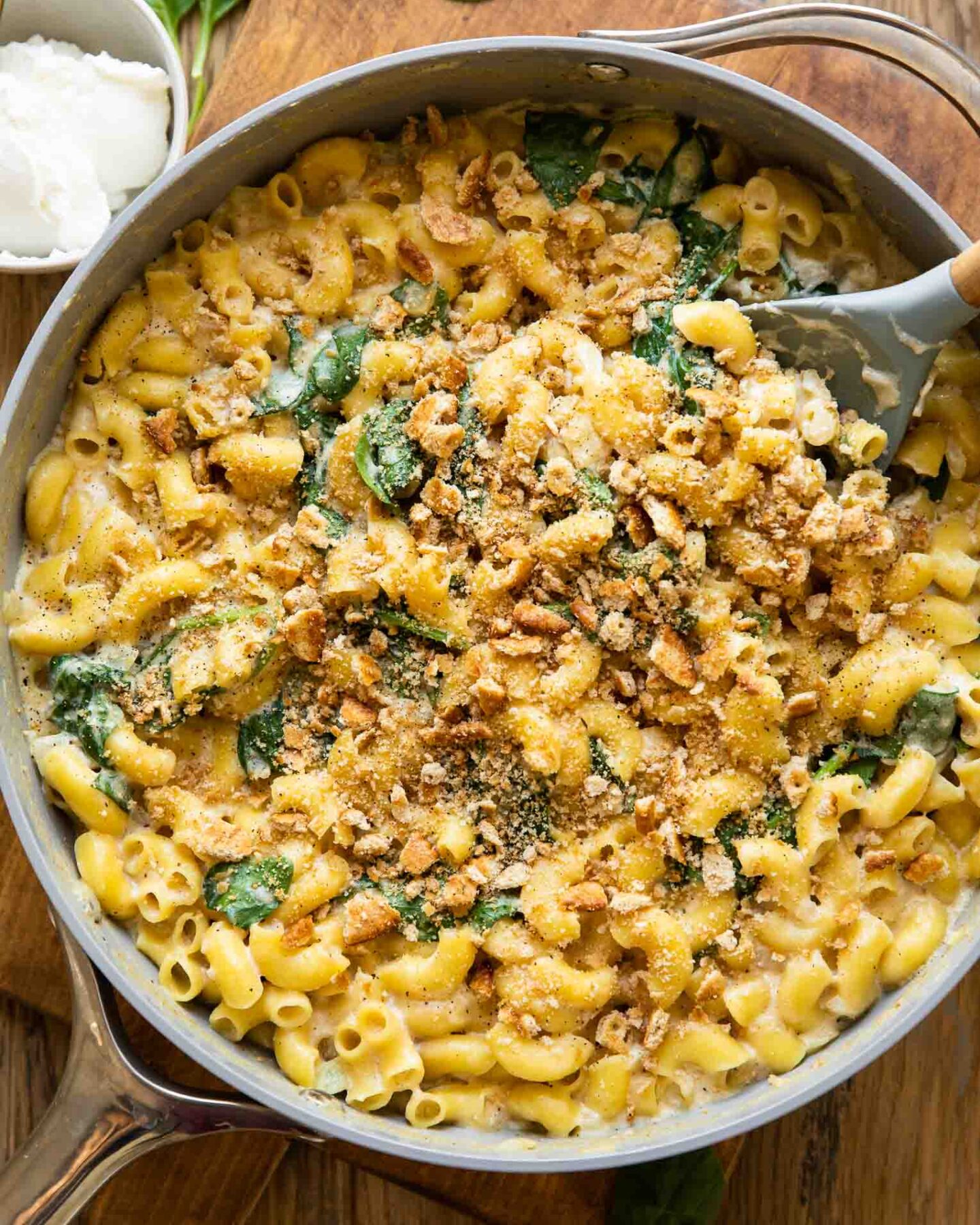 Spinach Ricotta Mac & Cheese being made in a skillet with a spoon.