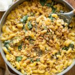 Spinach Ricotta Mac & Cheese being made in a skillet with a spoon.