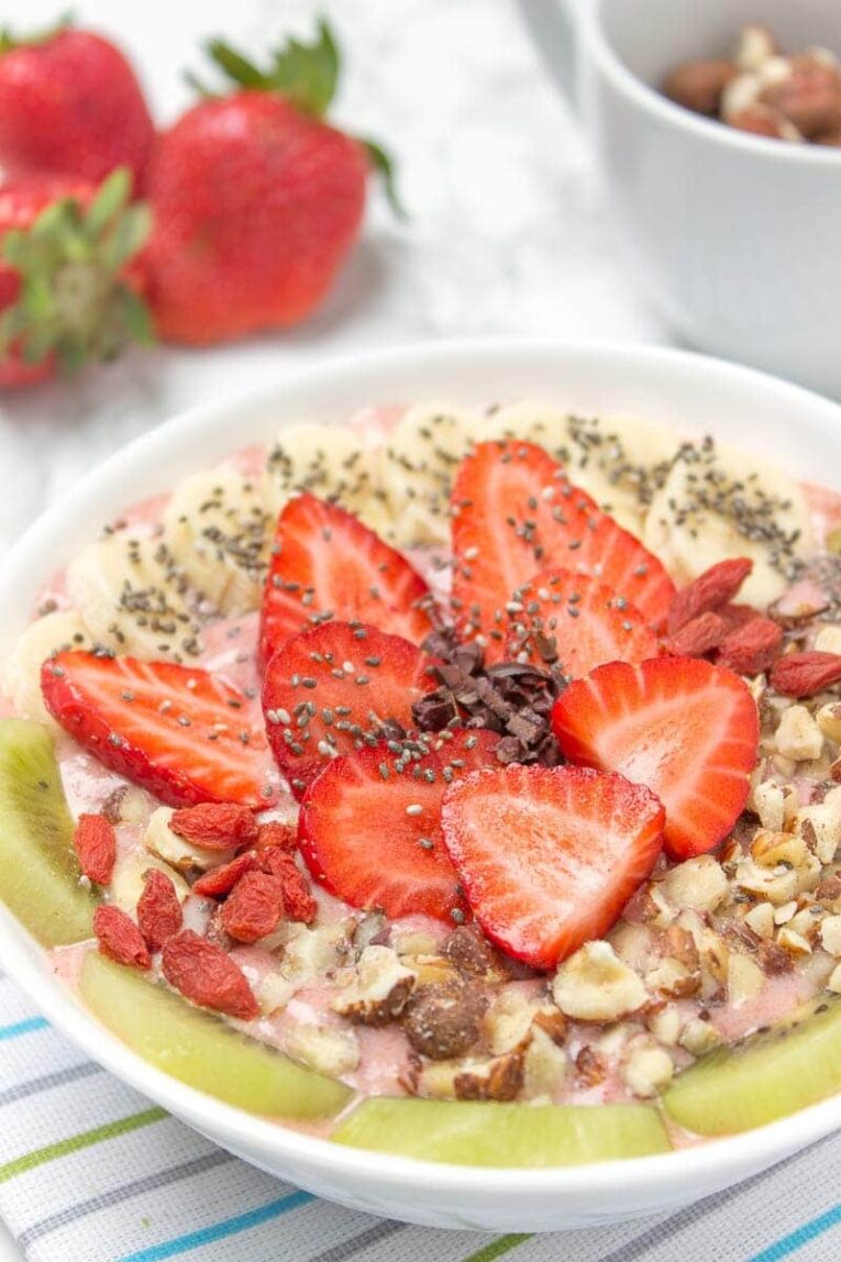 Strawberry Smoothie Bowl with ginger and fresh fruit in a white bowl.