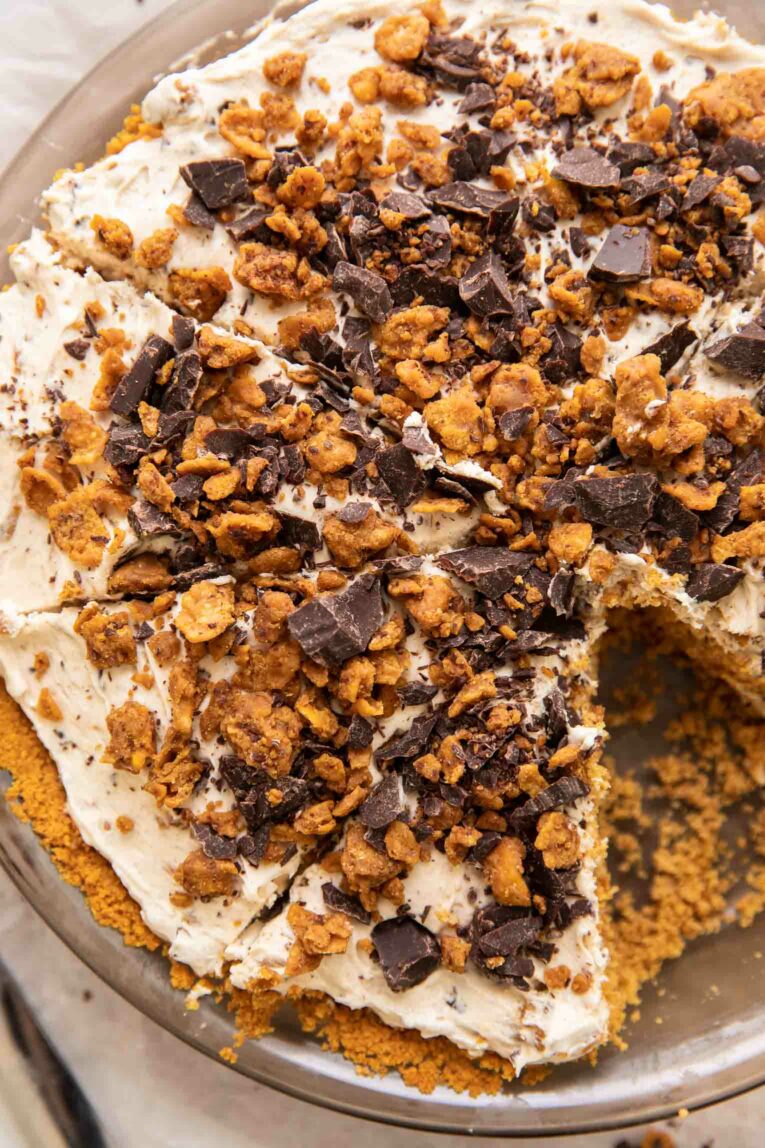 Close up of vegan cheesecake topped with vegan butterfinger and graham cracker crust.