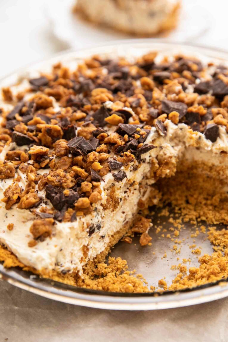 Angled photo of vegan butterfinger cheesecake with slices taken out.