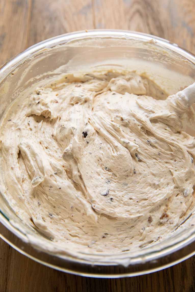 Vegan cheesecake filling being mixed in a large bowl.