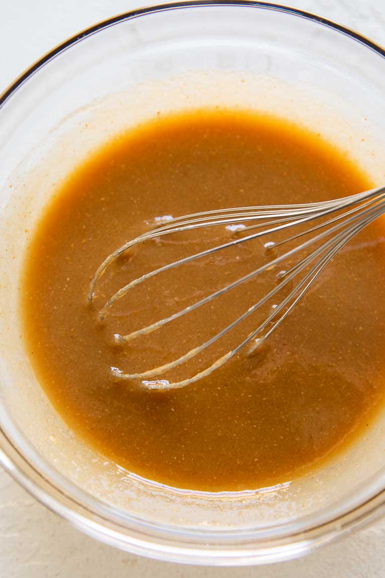 Chocolate cookie liquid ingredients being whisked in a bowl.