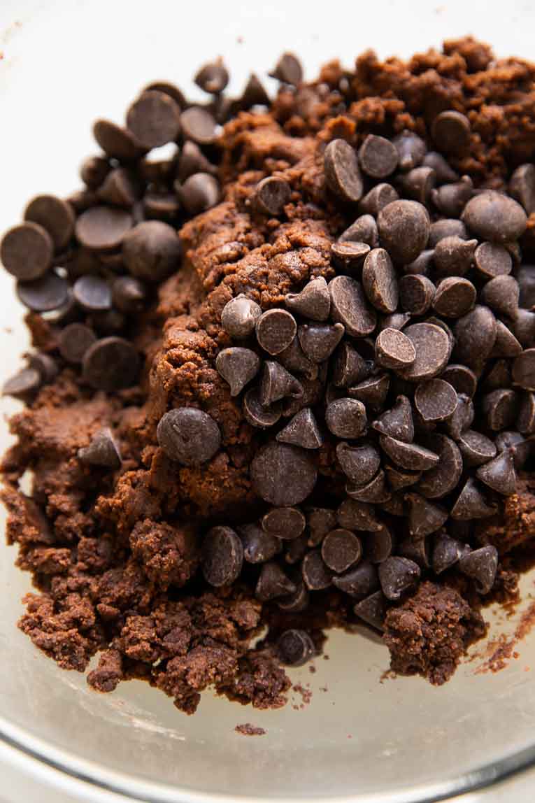 Vegan chocolate chip cookie dough being mixed in a glass bowl.