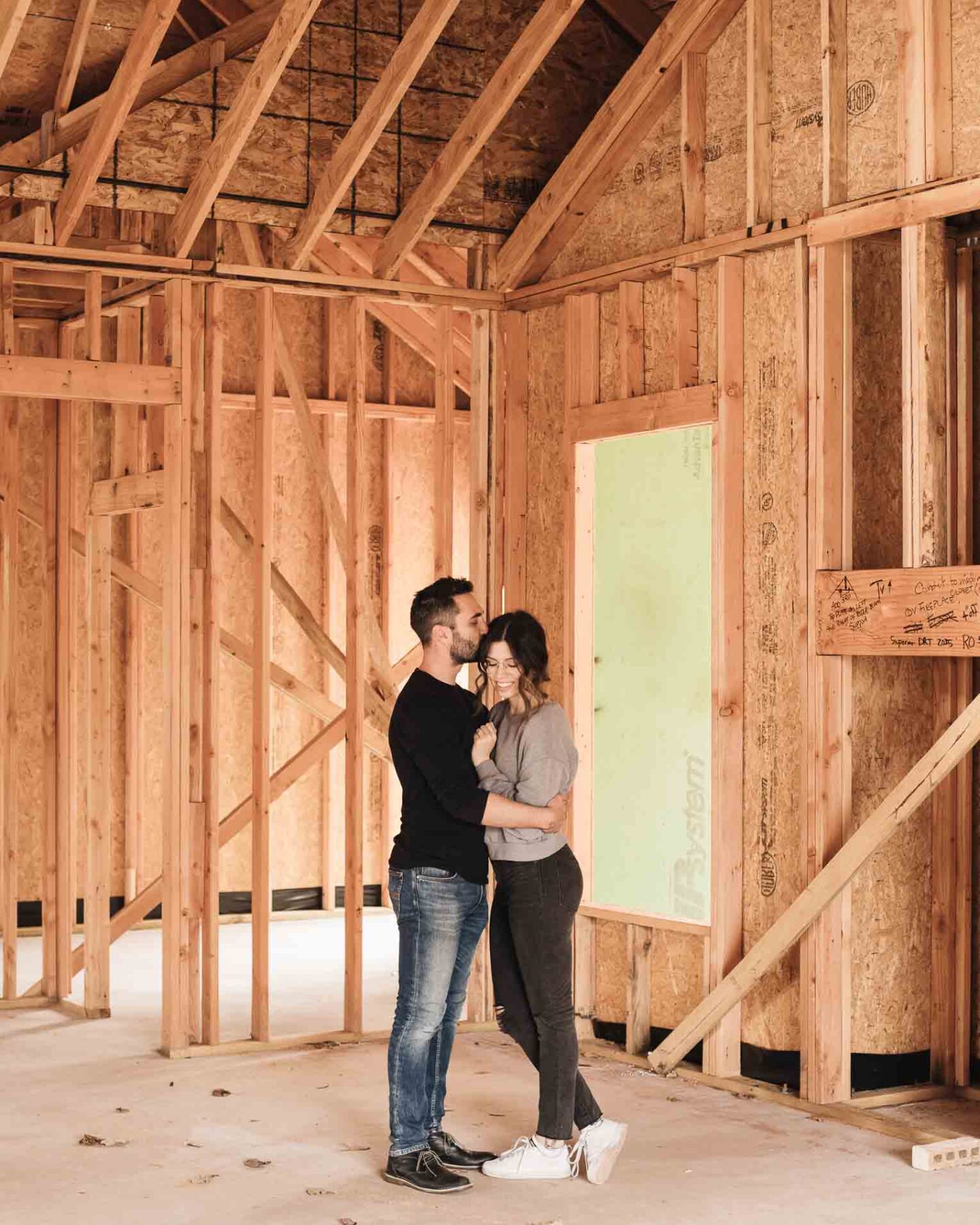 Husband and wife in framed living room in new build house.