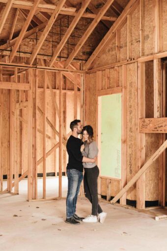 Husband and wife in framed living room in new build house.