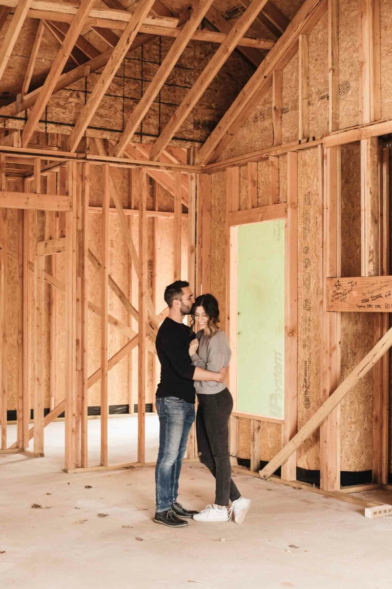 Husband and wife in framed living room in new build house.