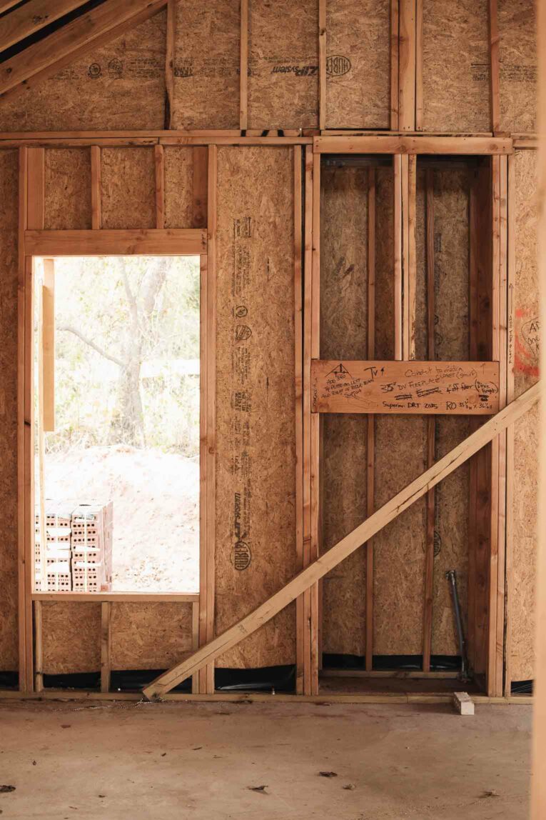 Window and fireplace in framed house.