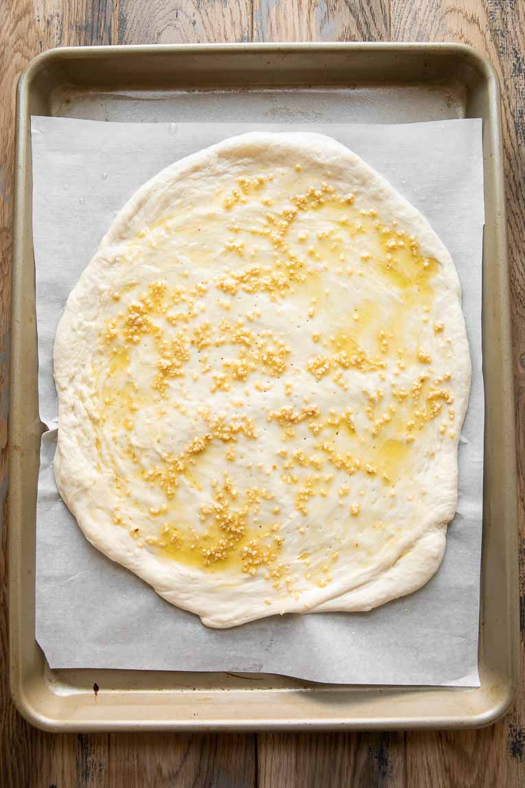 Pizza dough topped with olive oil and garlic.