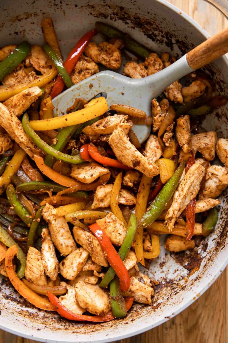 Fajita veggies and chicken in a skillet.