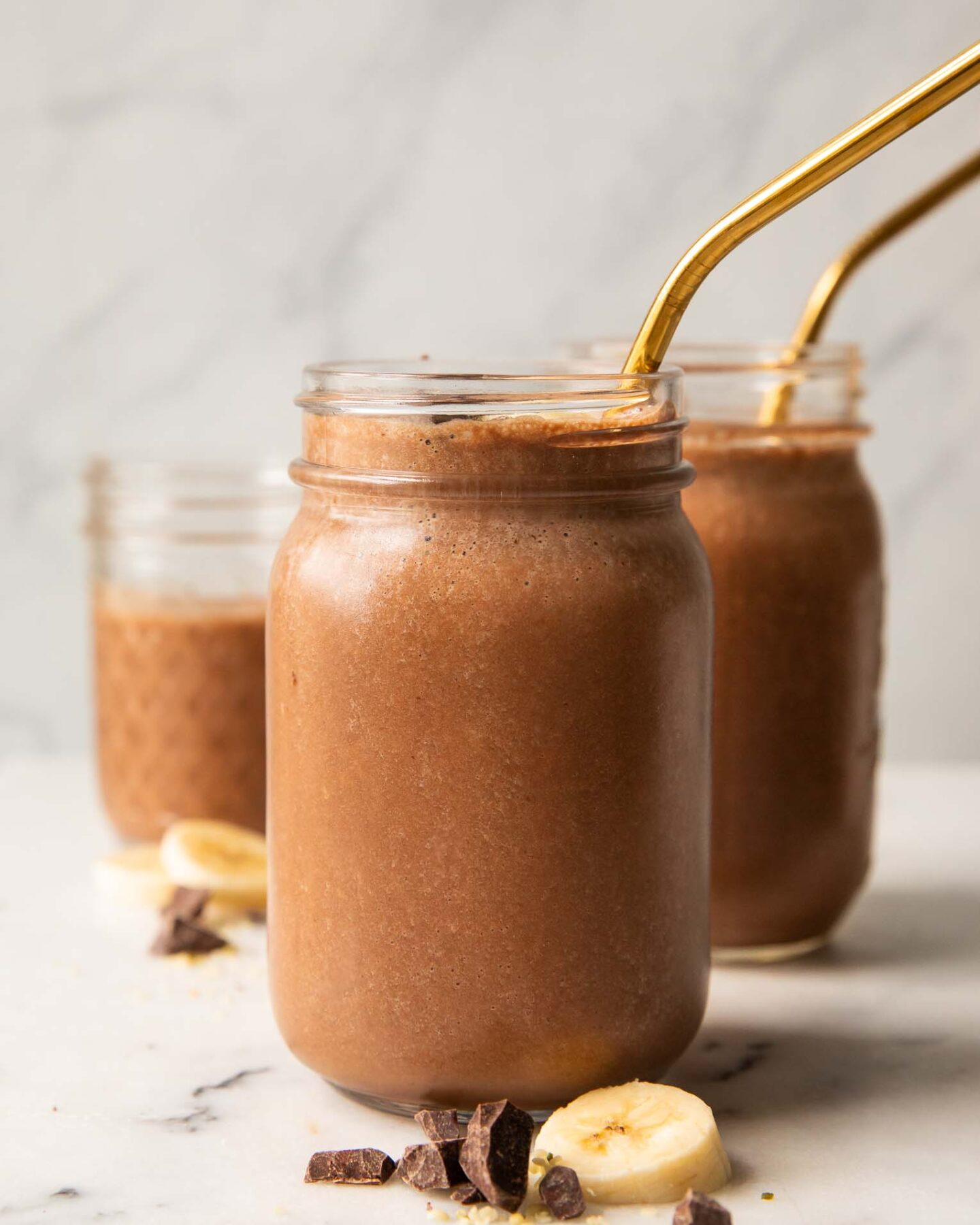 Chocolate banana smoothie recipe in a mason jar with a straw.