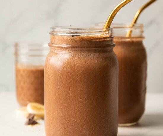Chocolate banana smoothie recipe in a mason jar with a straw.