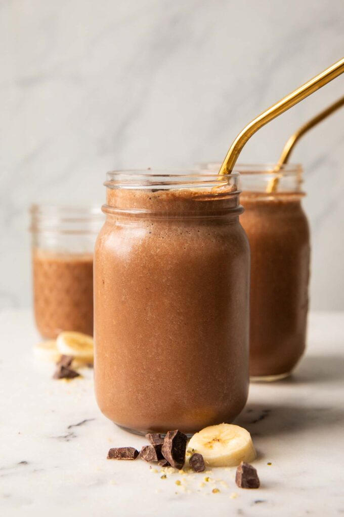 Chocolate banana smoothie recipe in a mason jar with a straw.