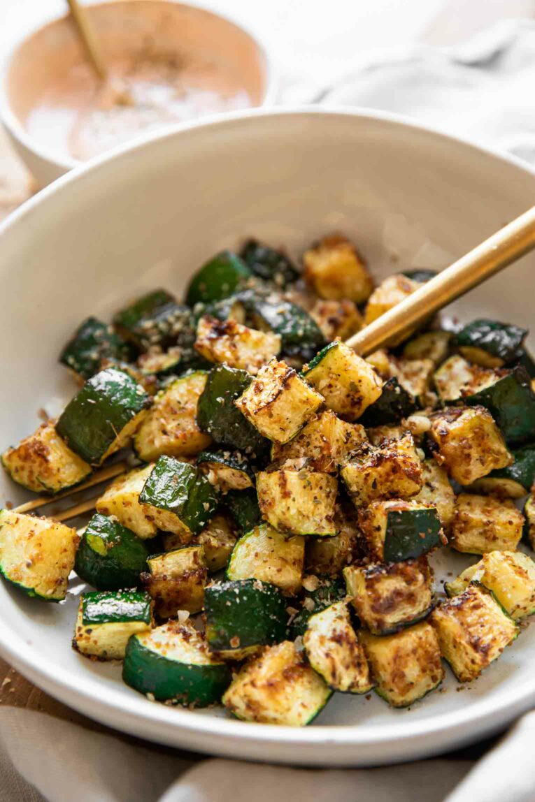 Angled photo of air fryer zucchini in a bowl.