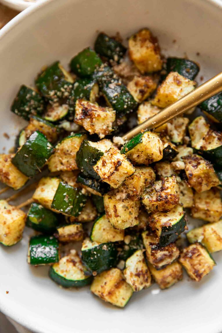 Top shot of crispy air fryer zucchini in a bowl with a fork.