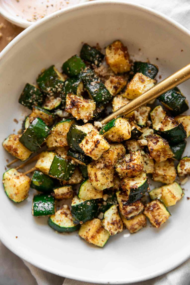 Top photo of air fryer zucchini in a white bowl
