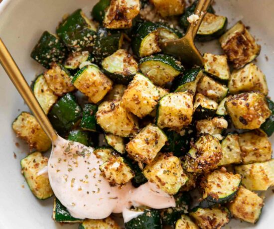 Crispy Air Fryer Zucchini in a bowl with yogurt sriracha sauce.