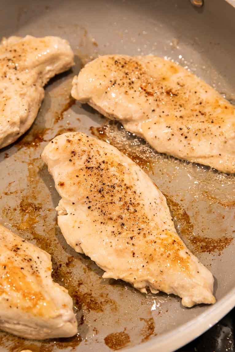 Chicken being cooked in a pan.