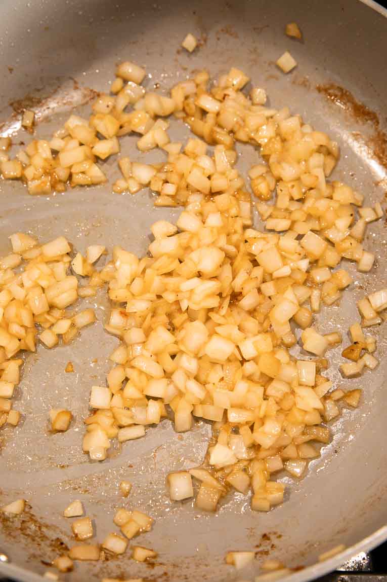 Yellow onion being cooked in a pan.