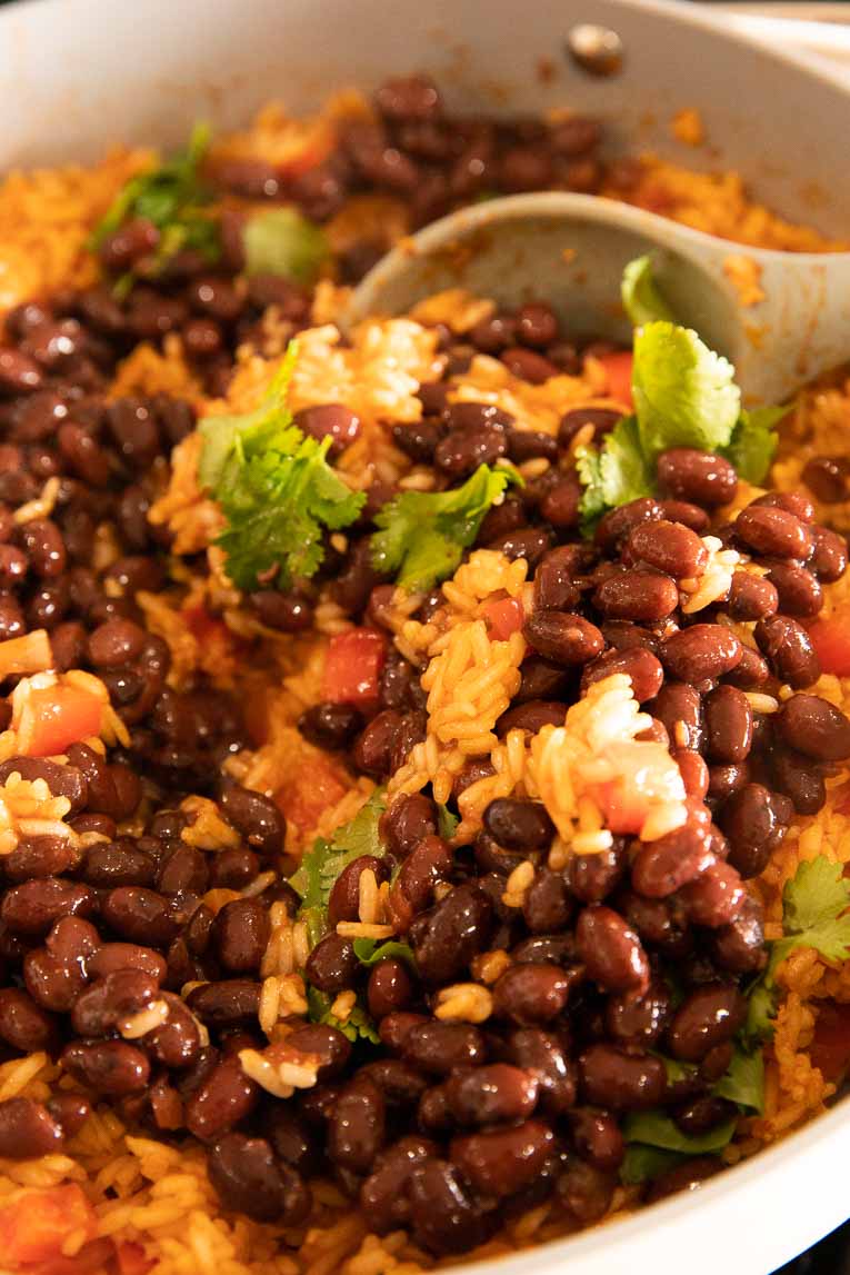 Spanish rice and red beans with cilantro being cooked.
