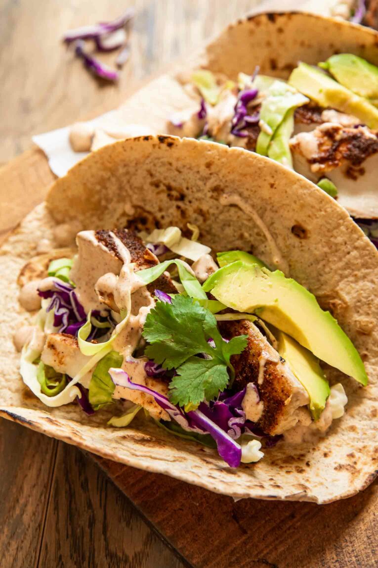 Angled photo of baked mahi mahi taco in flour tortilla.