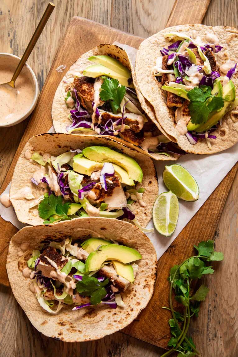 Top photo of tacos filled with baked mahi mahi, cabbage, and avocado.