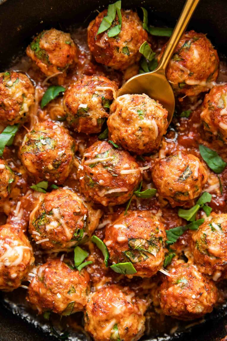Close up of baked chicken meatballs with marinara.