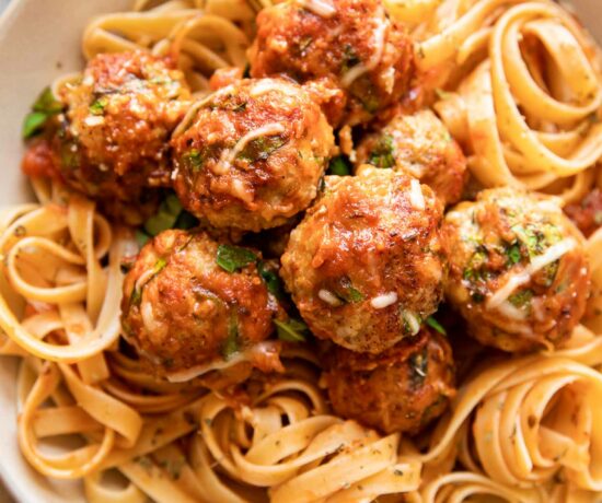 Baked Spinach Chicken Meatballs in a dish with fettuccine.